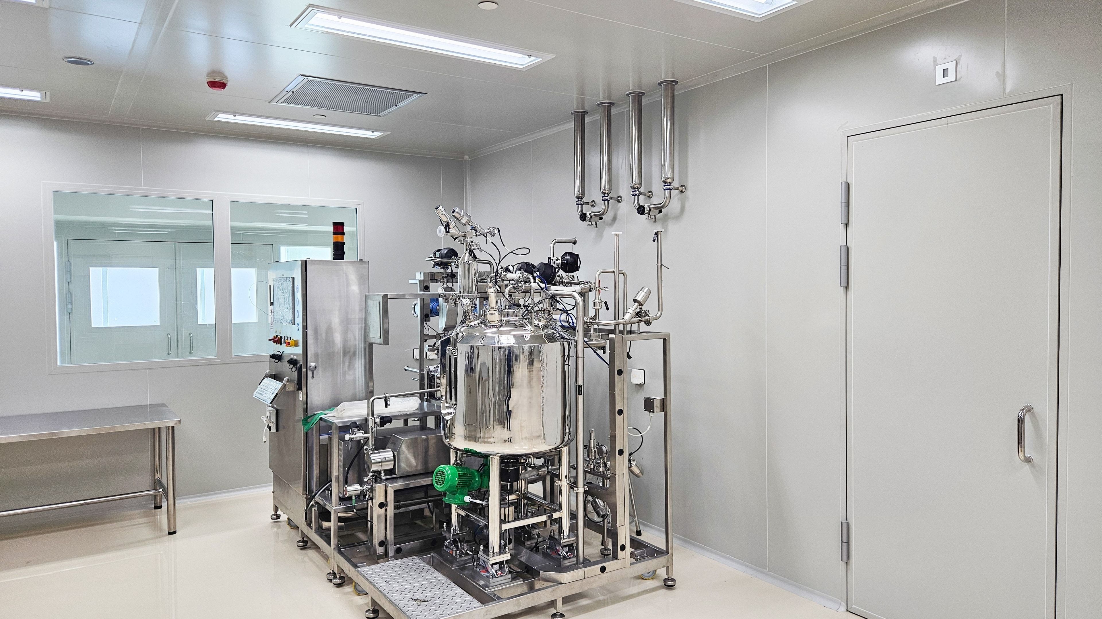 Interior de una sala blanca farmacéutica con equipos de acero inoxidable