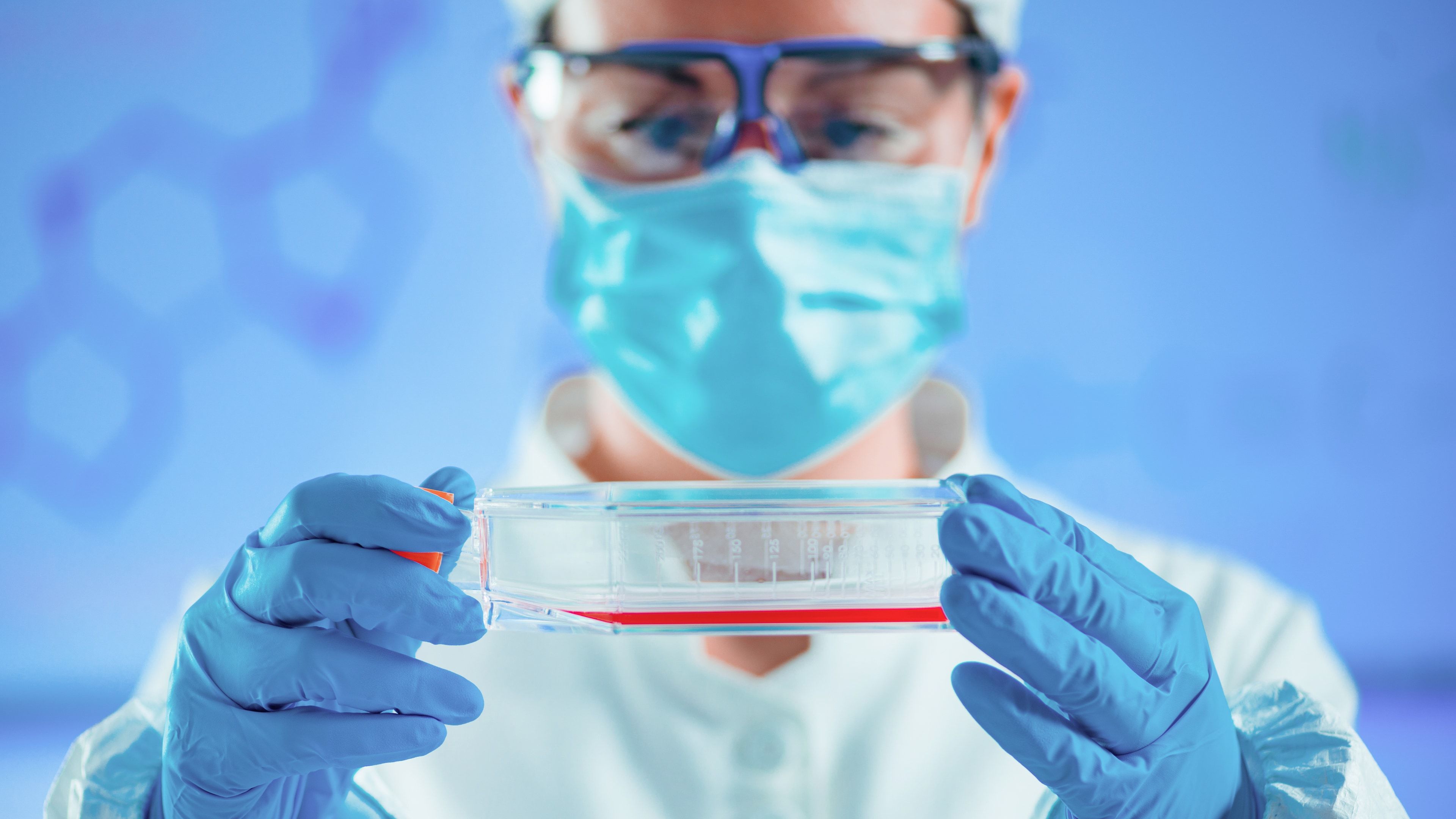 Científica trabajando con cultivos celulares en un laboratorio de biología