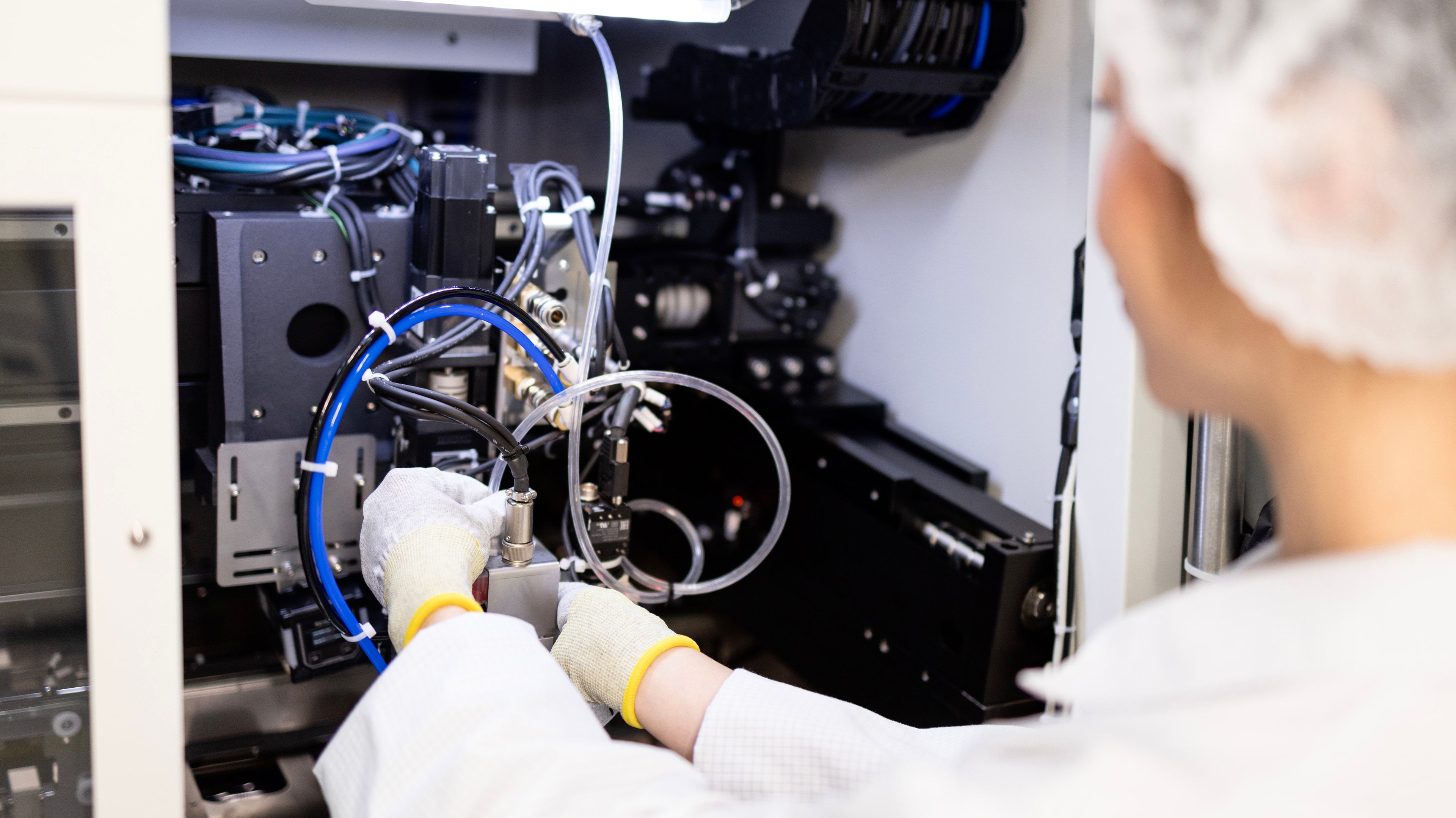 Ingeniero de mecatrónica junto a una máquina prototipo de precisión